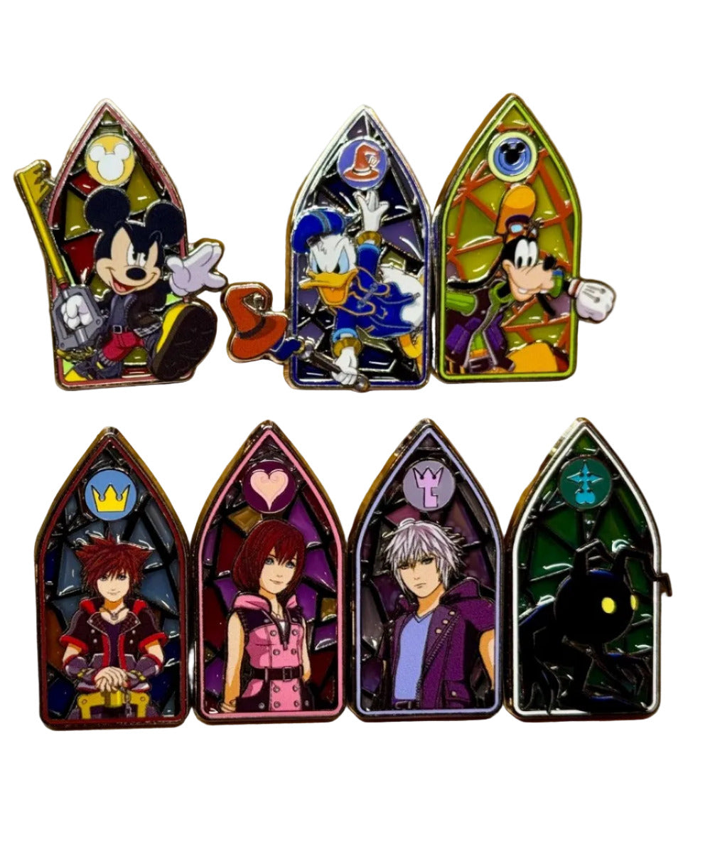 Set of Disney-themed pins on a wooden surface with packaging.