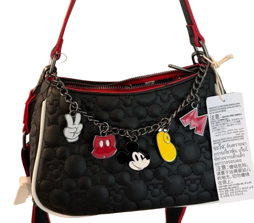 Black handbag with Mickey Mouse charms and a visible tag on a white background