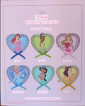Disney Princess collectible pins with characters in heart shapes on a pink background