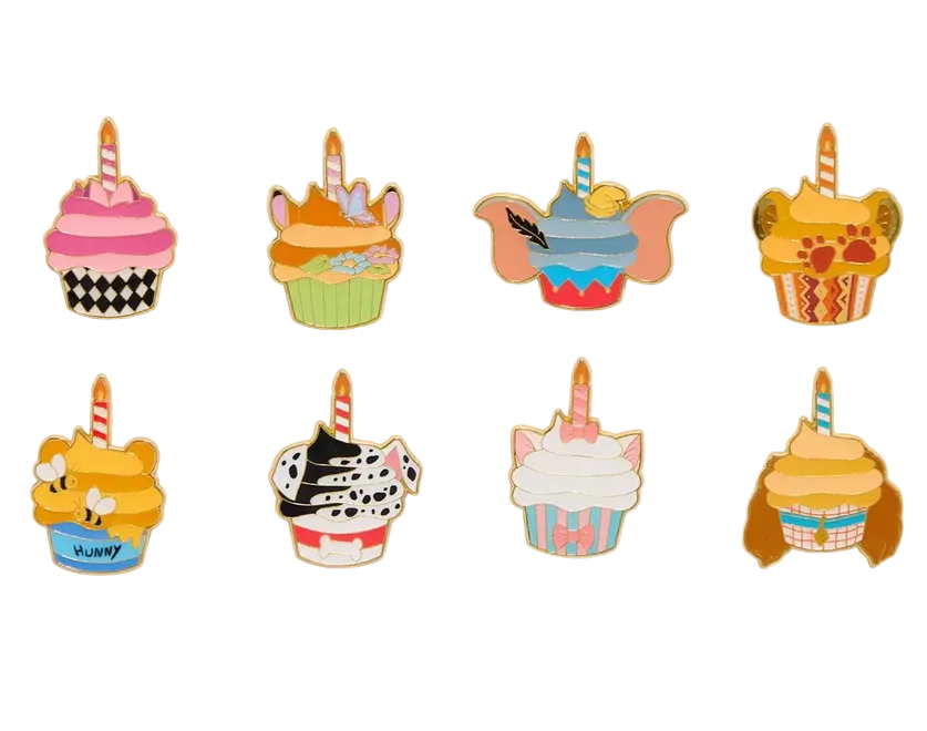 Set of colorful cupcake-shaped pins with various designs on a white background